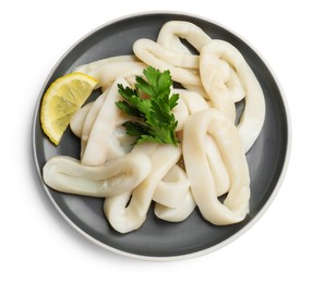 Photo of Raw squid rings, parsley and lemon isolated on white, top view
