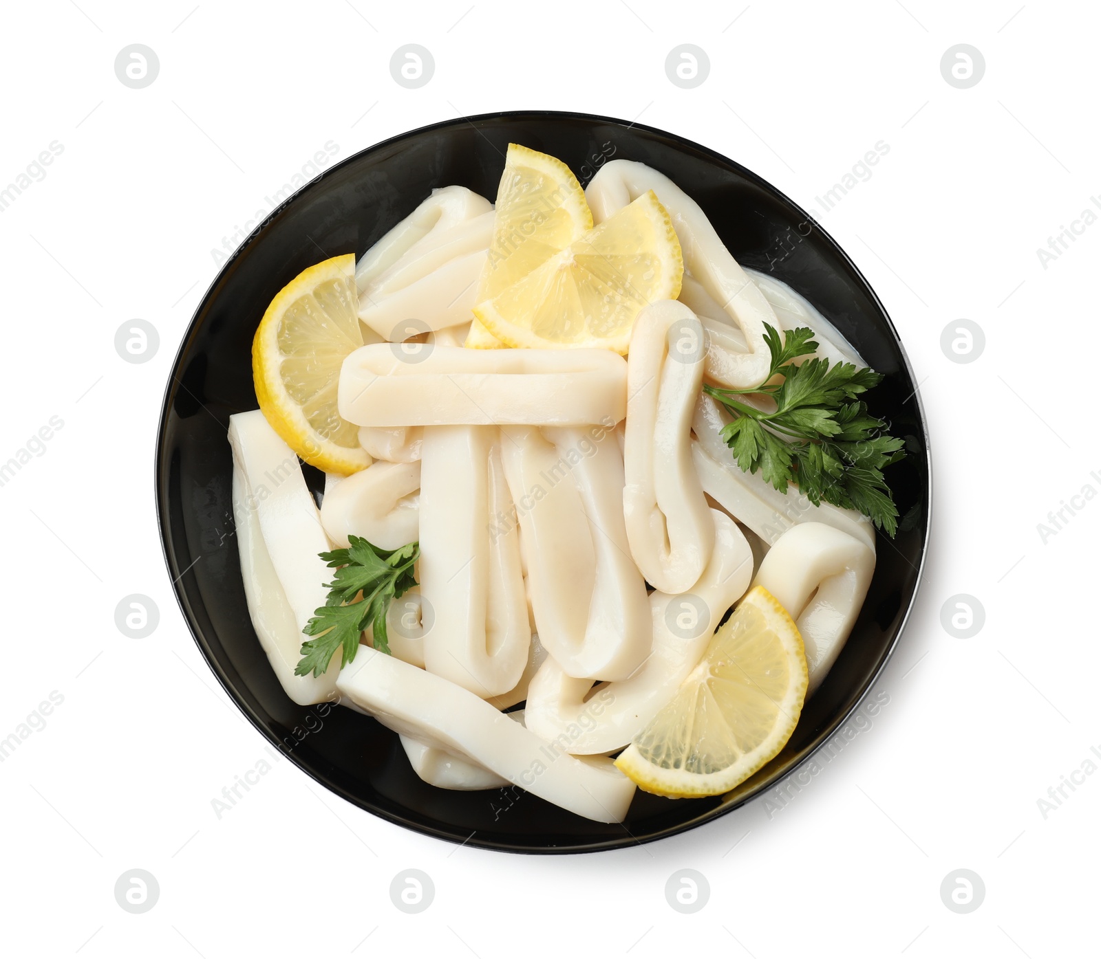 Photo of Raw squid rings, lemon and parsley in bowl isolated on white, top view