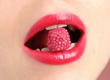 Photo of Woman with beautiful lips makeup and raspberry candy, closeup