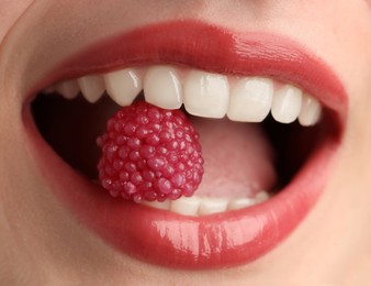 Photo of Woman with beautiful lips makeup and raspberry candy, closeup
