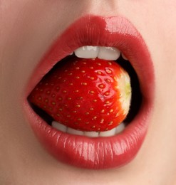 Photo of Woman with beautiful lips makeup and strawberry, closeup