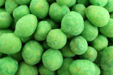Photo of Tasty wasabi coated peanuts as background, closeup