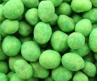 Photo of Tasty wasabi coated peanuts as background, closeup