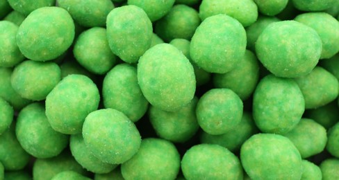 Photo of Tasty wasabi coated peanuts as background, closeup
