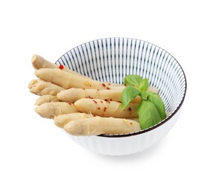 Photo of Pickled asparagus spears with spices and basil isolated on white