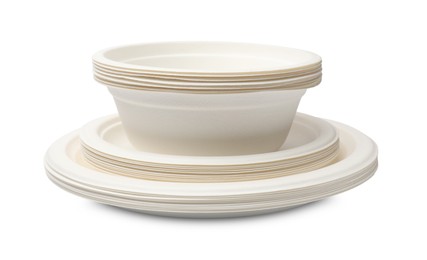 Photo of Disposable tableware. Stack of paper bowls and plates isolated on white