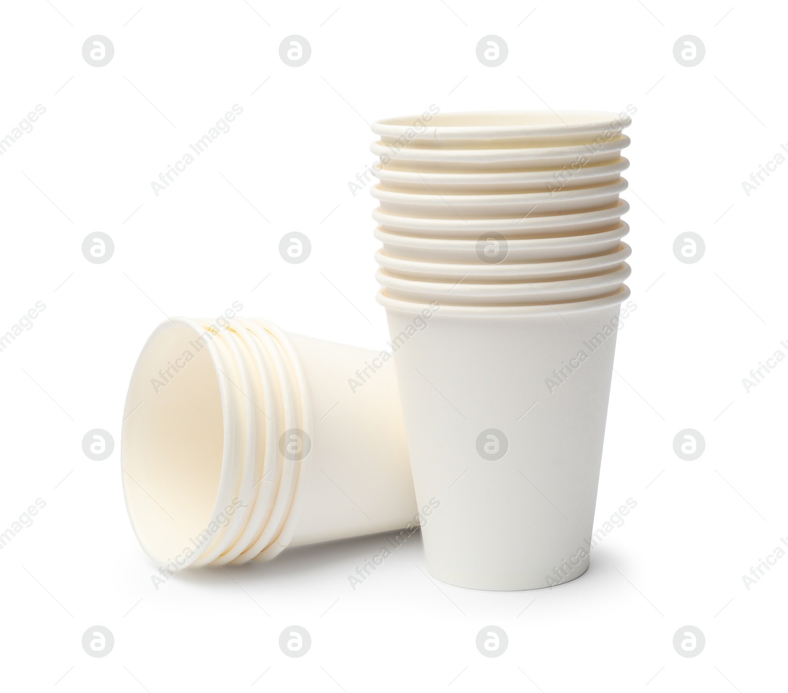 Photo of Disposable tableware. Stacks of paper cups isolated on white