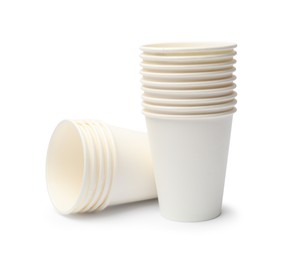 Photo of Disposable tableware. Stacks of paper cups isolated on white