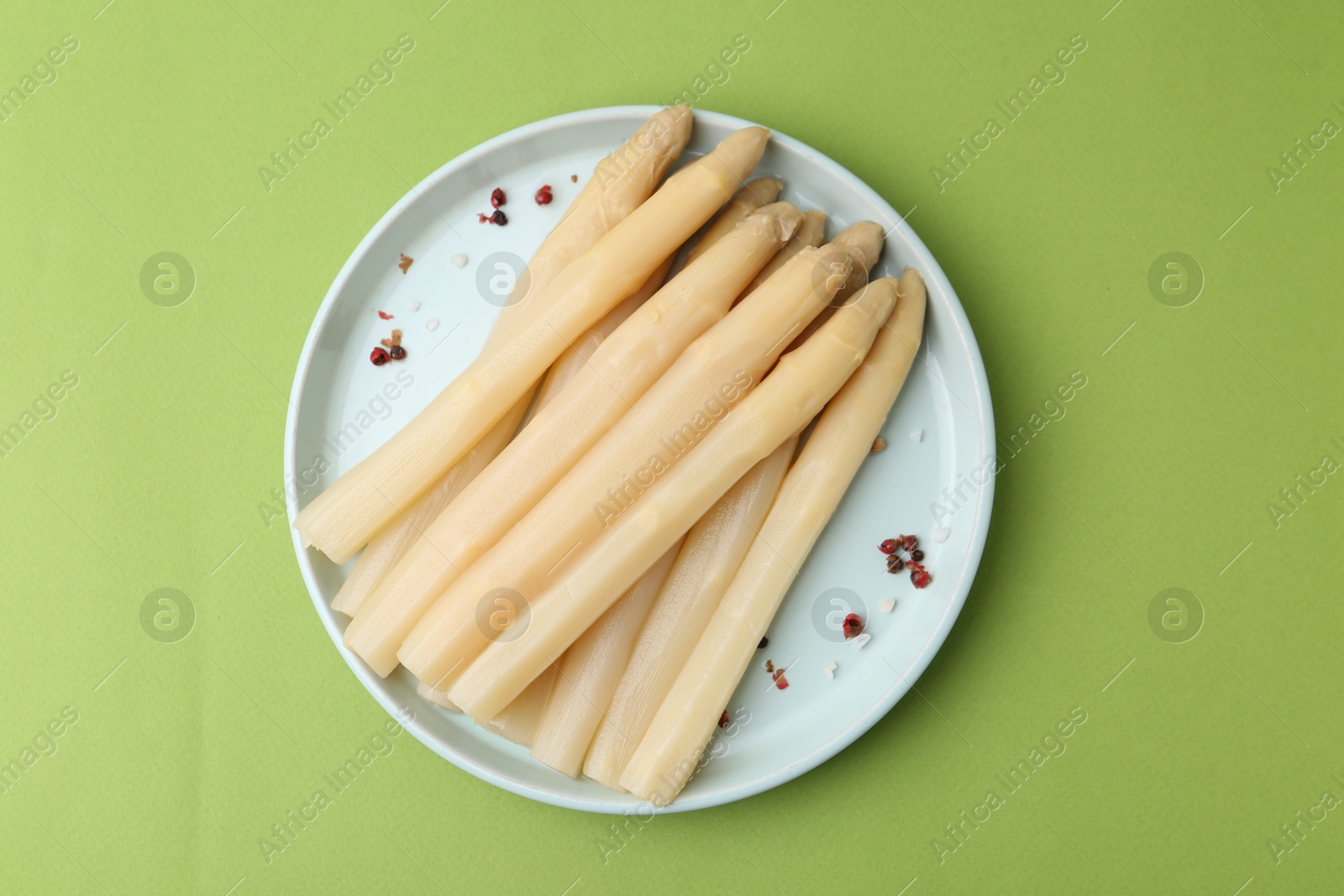 Pickled asparagus spears with spices on green table, top view Photo of Pickled asparagus spears with spices on green table, top view