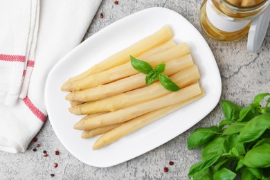 Photo of Pickled asparagus, basil and spices on grey table, flat lay