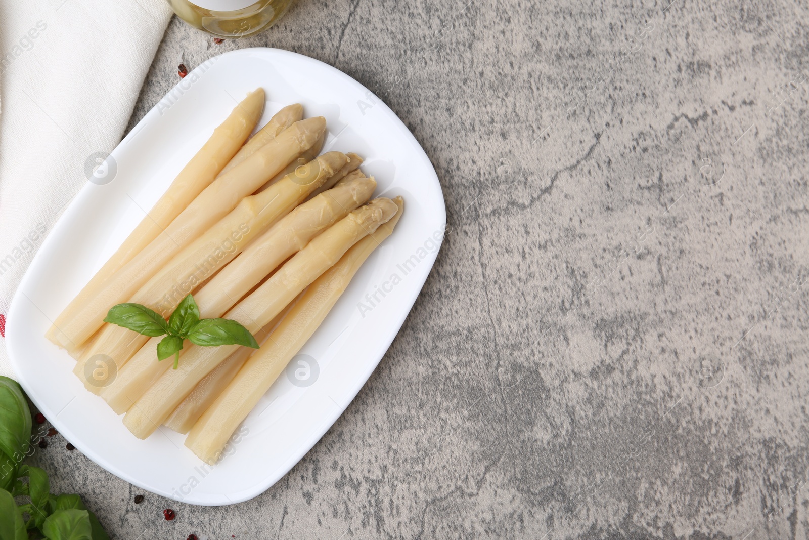 Pickled asparagus, basil and spices on grey table, flat lay. Space for text Photo of Pickled asparagus, basil and spices on grey table, flat lay. Space for text