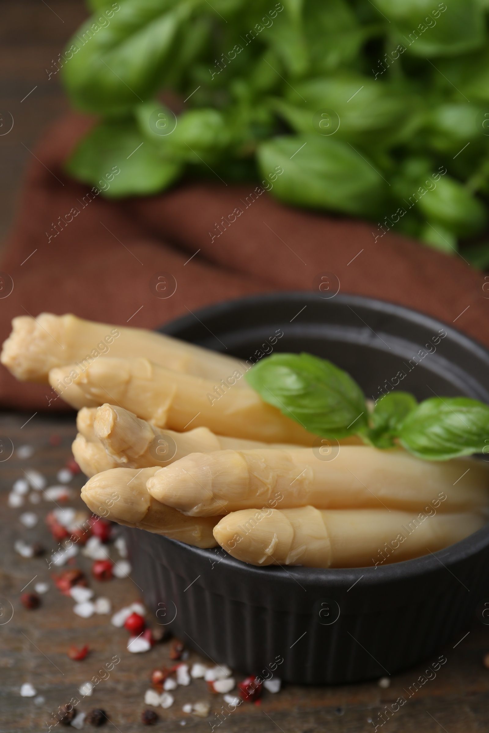 Pickled asparagus with basil and spices on wooden table, closeup Photo of Pickled asparagus with basil and spices on wooden table, closeup