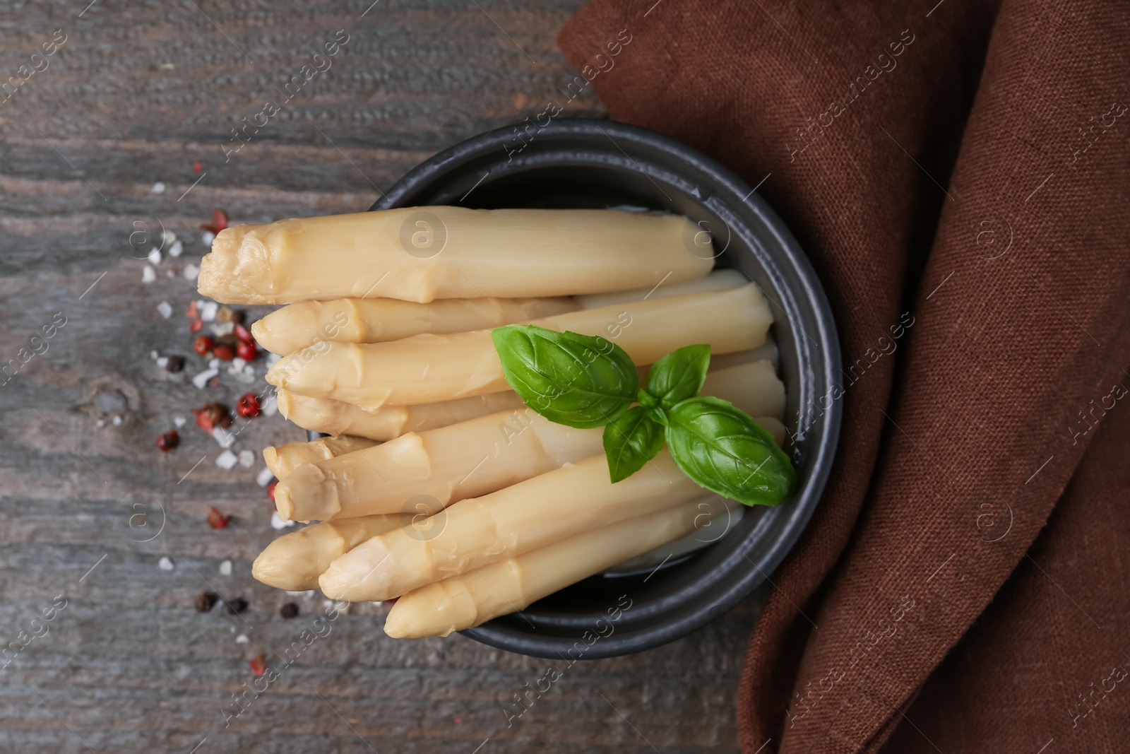 Pickled asparagus with basil and spices on wooden table, top view Photo of Pickled asparagus with basil and spices on wooden table, top view
