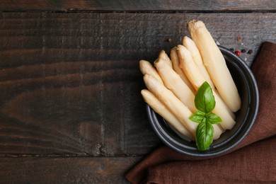 Photo of Pickled asparagus with basil and spices on wooden table, top view. Space for text