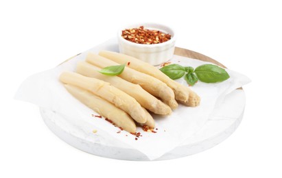 Photo of Pickled asparagus spears with spices and basil isolated on white