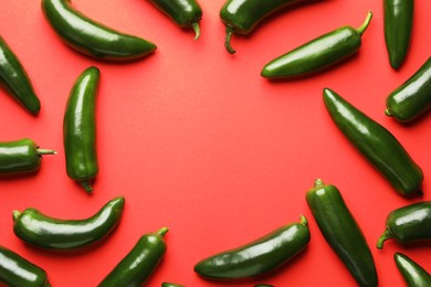 Photo of Frame of green jalapeno peppers on red background, flat lay. Space for text