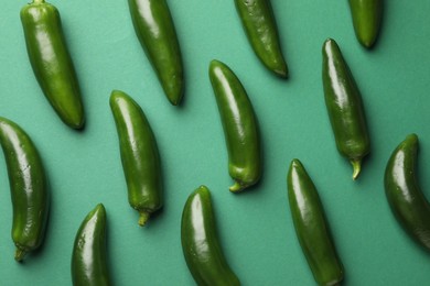 Photo of Ripe jalapeno peppers on green background, flat lay