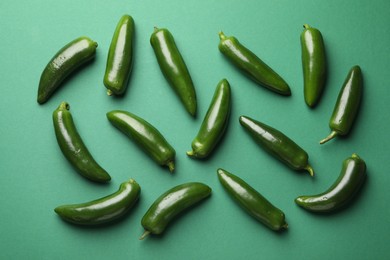 Photo of Ripe jalapeno peppers on green background, flat lay