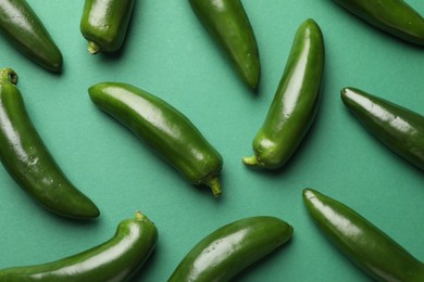 Photo of Ripe jalapeno peppers on green background, flat lay
