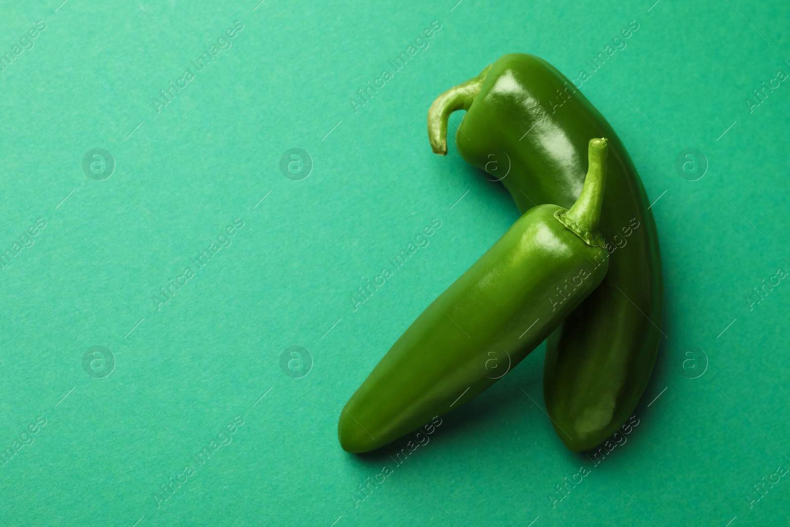 Ripe jalapeno peppers on green background, flat lay. Space for text Photo of Ripe jalapeno peppers on green background, flat lay. Space for text