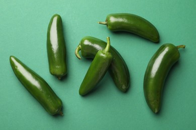 Photo of Ripe jalapeno peppers on green background, flat lay