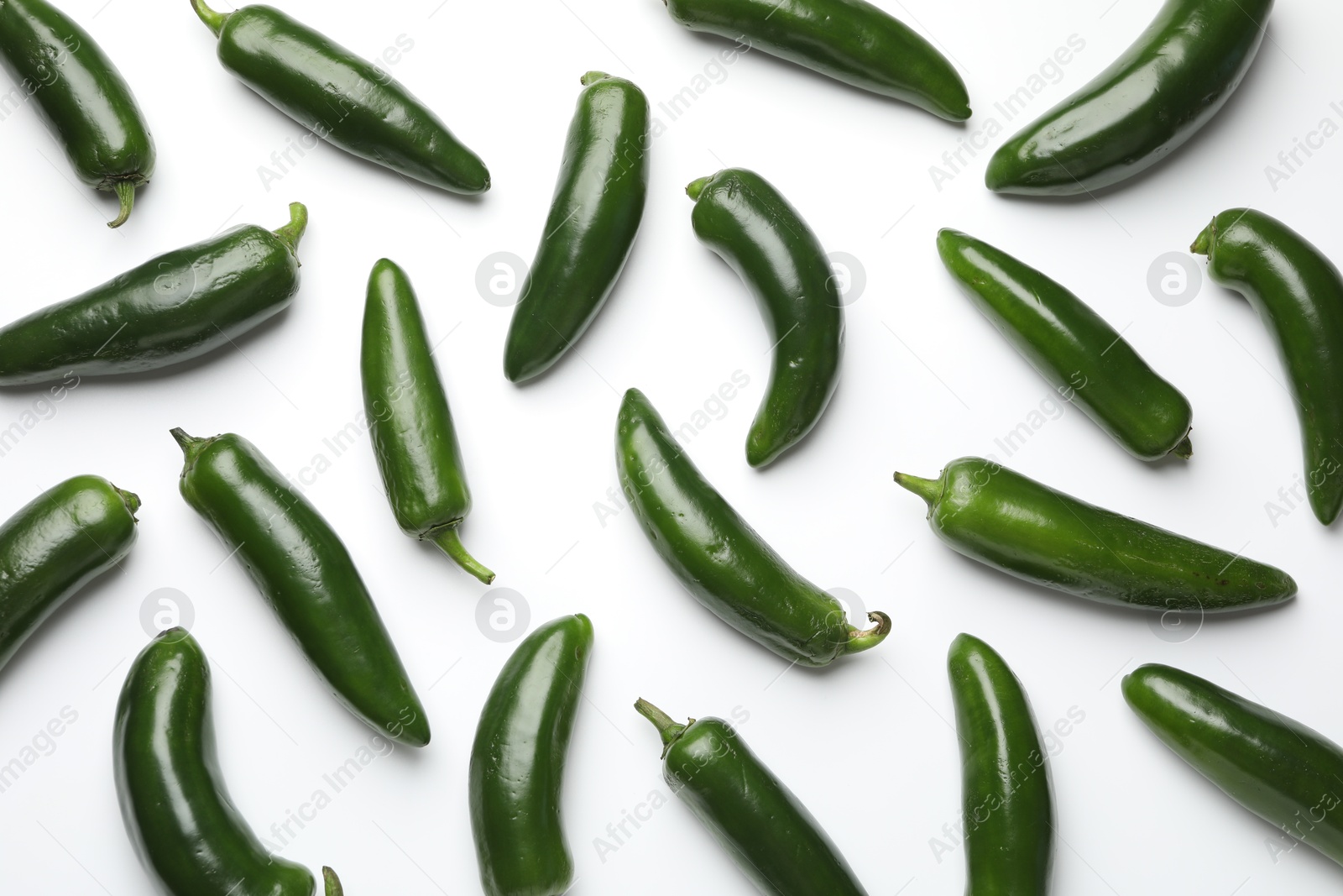 Photo of Green jalapeno peppers on white background, flat lay