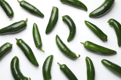 Photo of Green jalapeno peppers on white background, flat lay