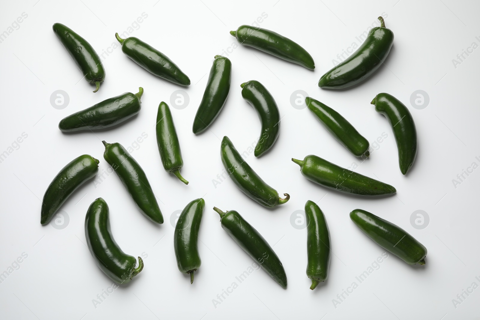 Photo of Green jalapeno peppers on white background, flat lay