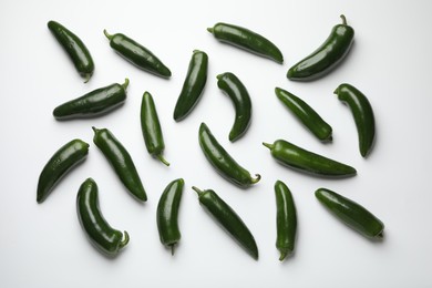 Photo of Green jalapeno peppers on white background, flat lay