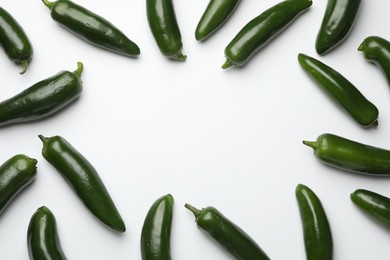 Photo of Frame of green jalapeno peppers on white background, flat lay. Space for text