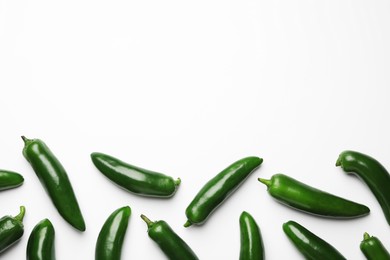 Photo of Green jalapeno peppers on white background, flat lay. Space for text