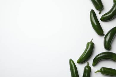 Photo of Green jalapeno peppers on white background, flat lay. Space for text