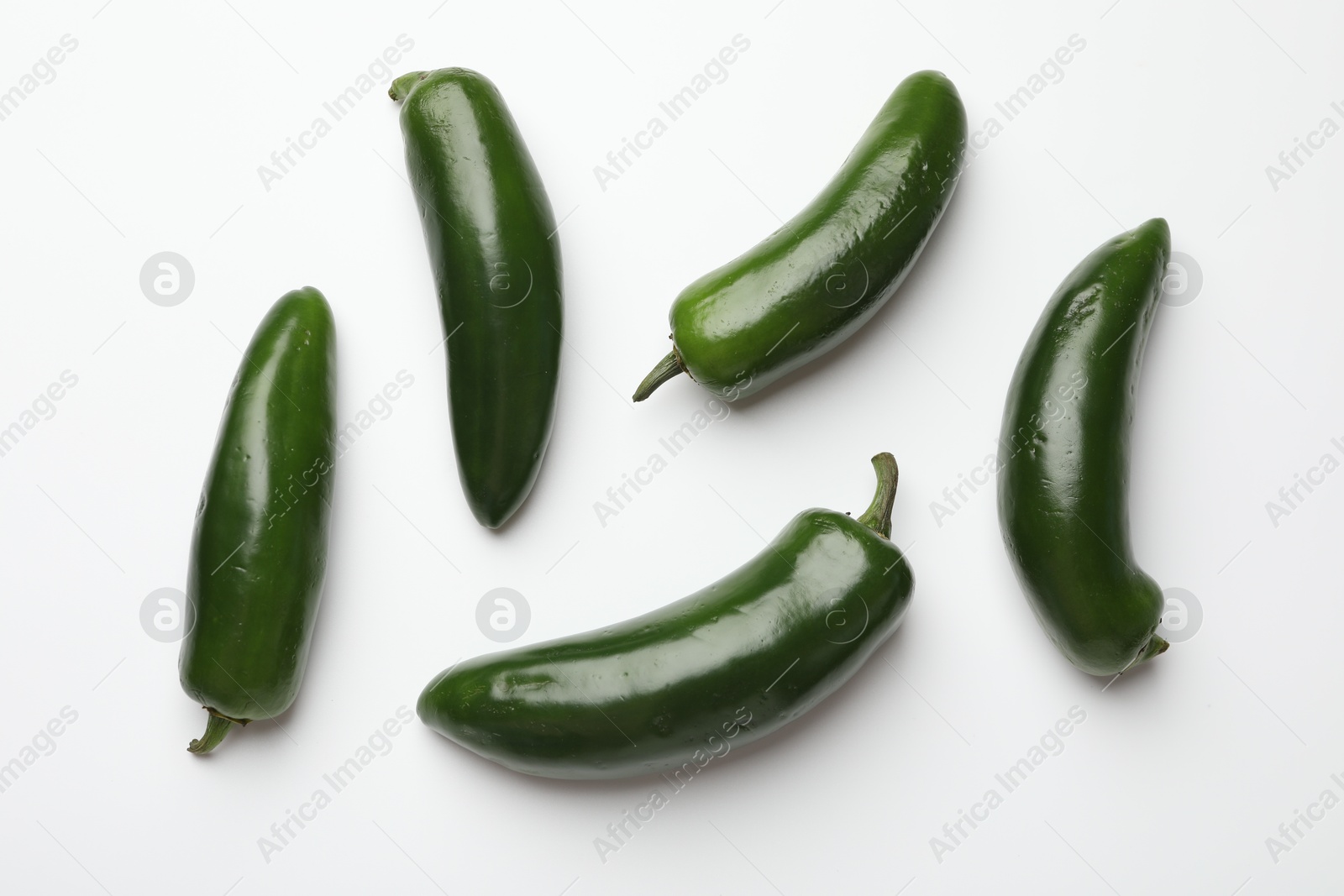 Photo of Green jalapeno peppers on white background, flat lay