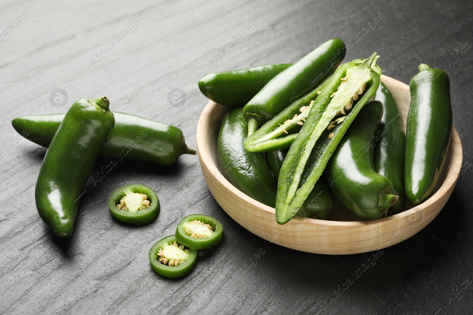 Photo of Ripe green jalapeno peppers on grey table, closeup