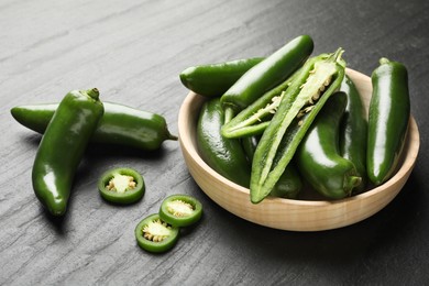 Photo of Ripe green jalapeno peppers on grey table, closeup