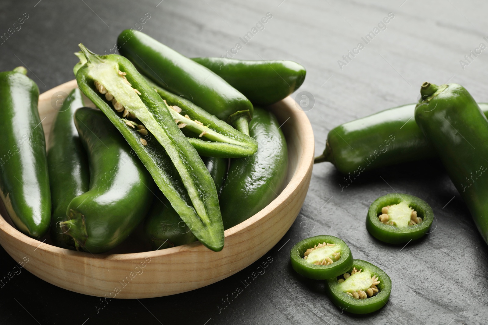 Photo of Ripe green jalapeno peppers on grey table, closeup