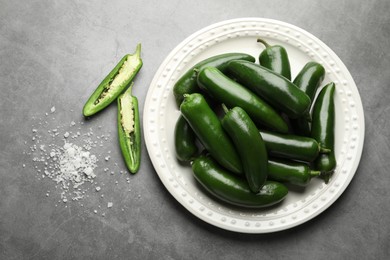 Photo of Ripe green jalapeno peppers and salt on grey table, flat lay