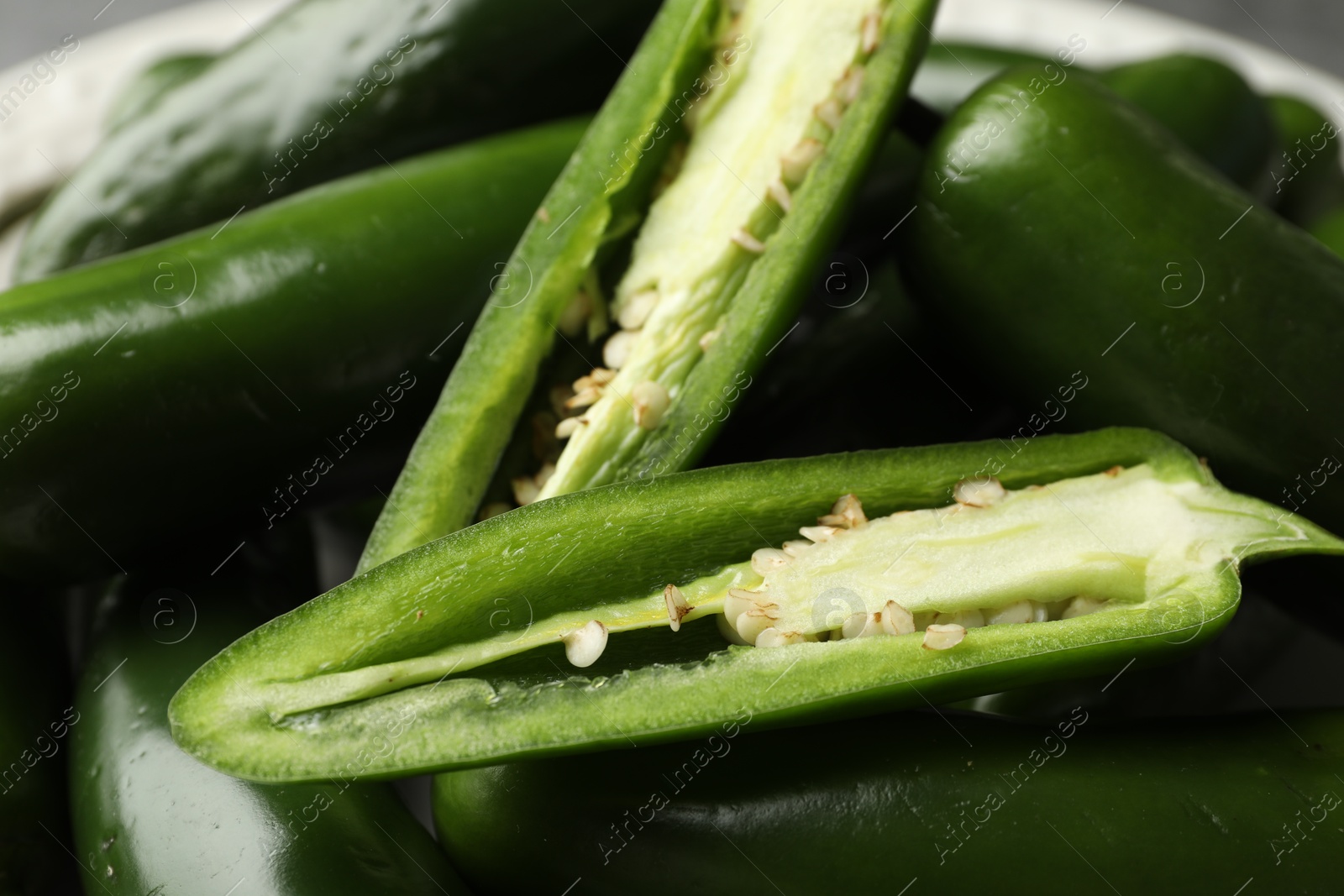 Photo of Ripe green jalapeno peppers on grey table, closeup