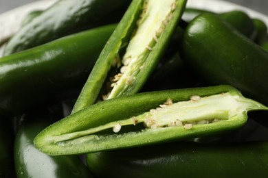 Photo of Ripe green jalapeno peppers on grey table, closeup