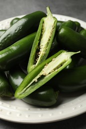 Photo of Ripe green jalapeno peppers on grey table, closeup