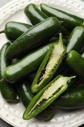 Photo of Ripe green jalapeno peppers on grey table, closeup
