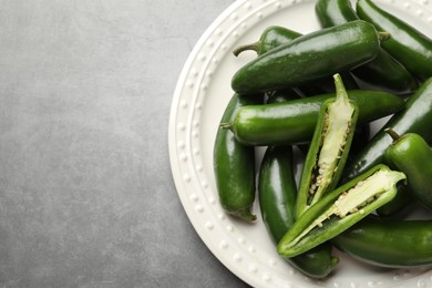 Photo of Ripe green jalapeno peppers on grey table, top view. Space for text