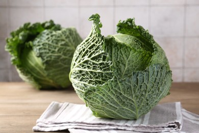 Photo of Fresh Savoy cabbages on wooden table, closeup