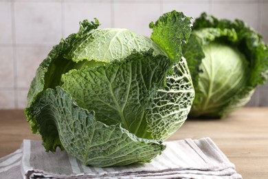 Photo of Fresh Savoy cabbages on wooden table, closeup