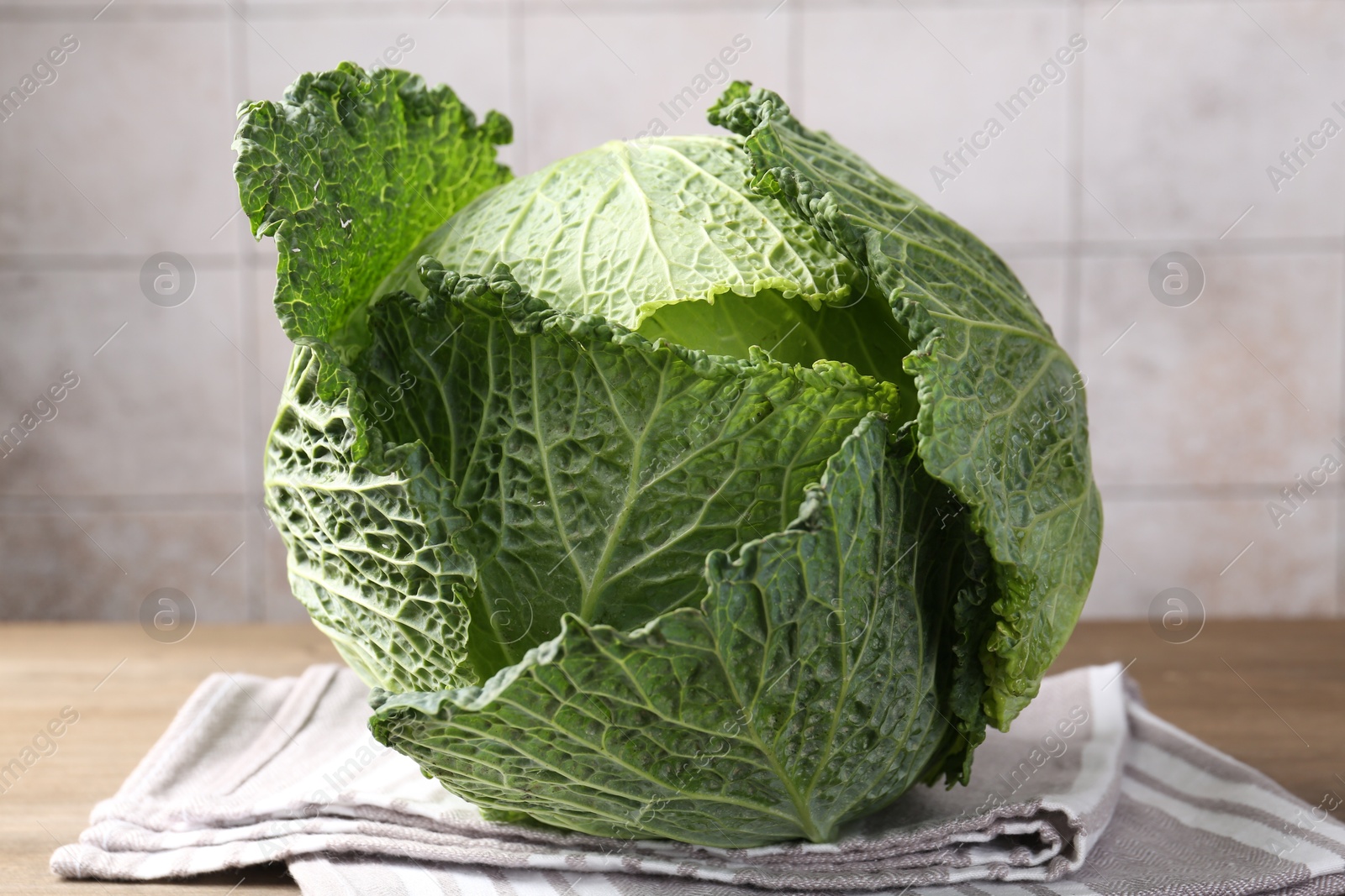 Photo of Fresh Savoy cabbage on wooden table, closeup
