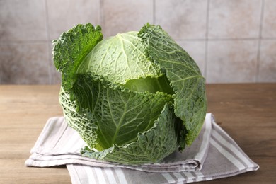 Photo of Fresh Savoy cabbage on wooden table, closeup