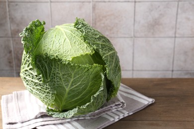 Photo of Fresh Savoy cabbage on wooden table, closeup. Space for text