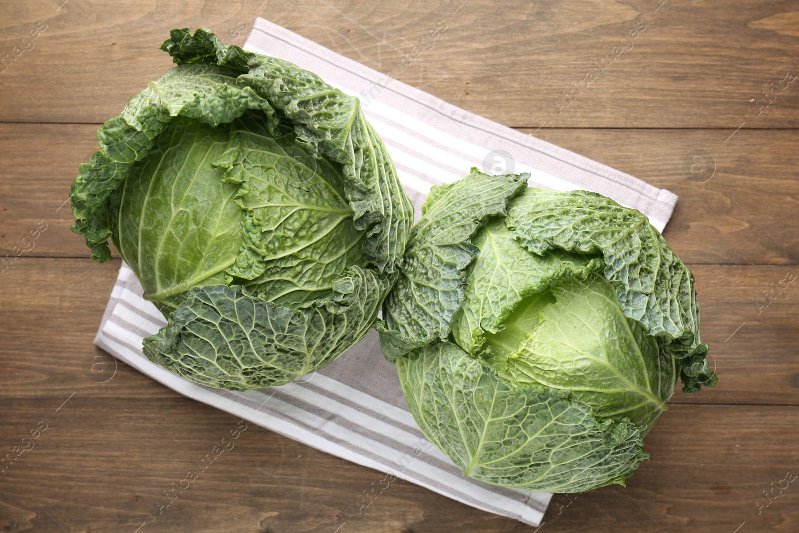 Photo of Fresh Savoy cabbages on wooden table, top view