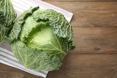 Photo of Fresh Savoy cabbages on wooden table, top view. Space for text