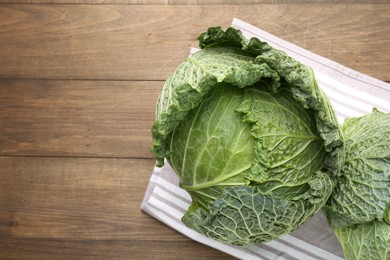Photo of Fresh Savoy cabbages on wooden table, top view. Space for text